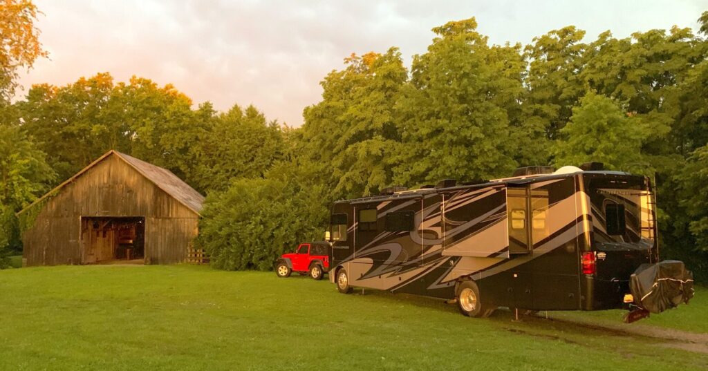 RVBlogger Class A RV in a field near a barn at sunset after a thunder storm