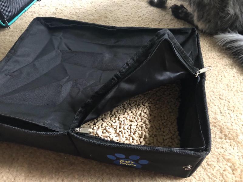 portable litter box showing cat litter inside and a zipper top so it can be transported