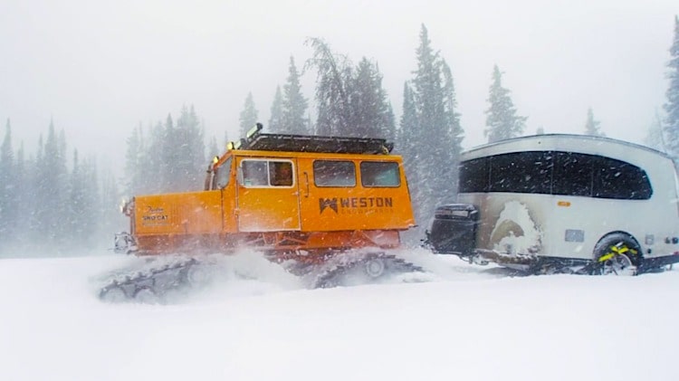 airstream in winter towed by a snow cat
