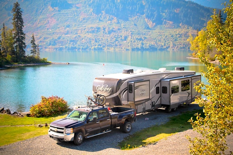 Large 5th wheel RV and dually truck parked beside a lake - 5th wheel disconnect