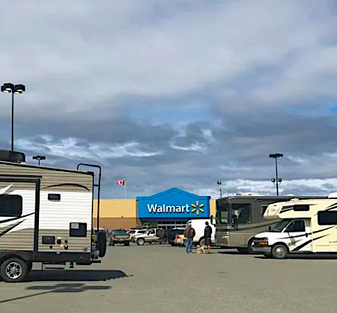 parking lot of a Walmart with at least 3 Rvs parking to spend the night