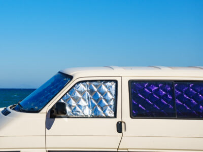 campvan with interior window covers parked by the ocean