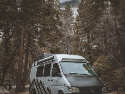 Camper van parked on the road in a forest