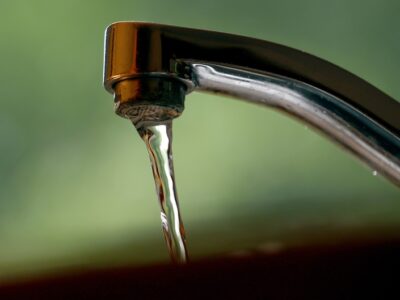 silver RV water faucet with water running