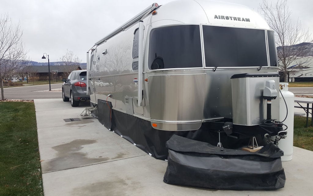 Airstream travel trailer with vinyl RV skirting around the bottom