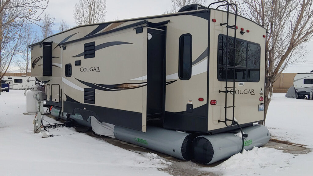 Travel trailer on at a snowy campground with AirSkirts installed
