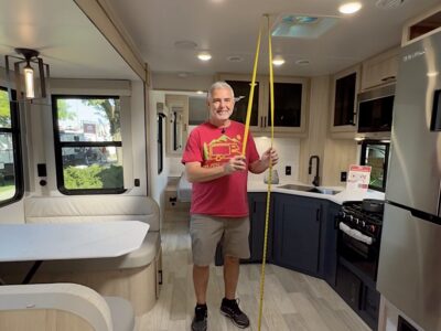 Mike from RVBlogger measuring the ceiling height of an RV camper with his tape measure