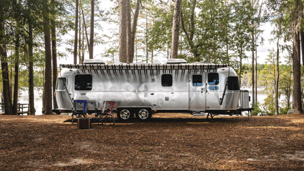 Airstream Classic parked in a lakeside campsite