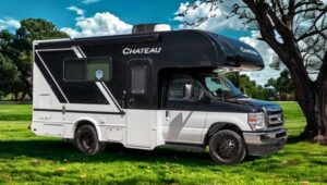 2026 white and black thor chateau class c motorhome on the grass in front of a tree