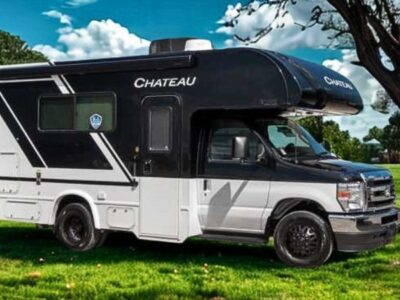 2026 white and black thor chateau class c motorhome on the grass in front of a tree
