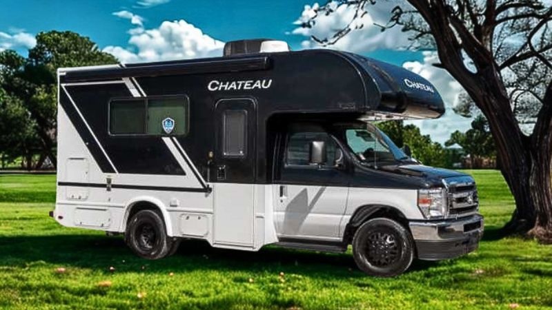 2026 white and black thor chateau class c motorhome on the grass in front of a tree