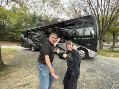 mike and susan from rvblogger standing in front of their new Class a rv